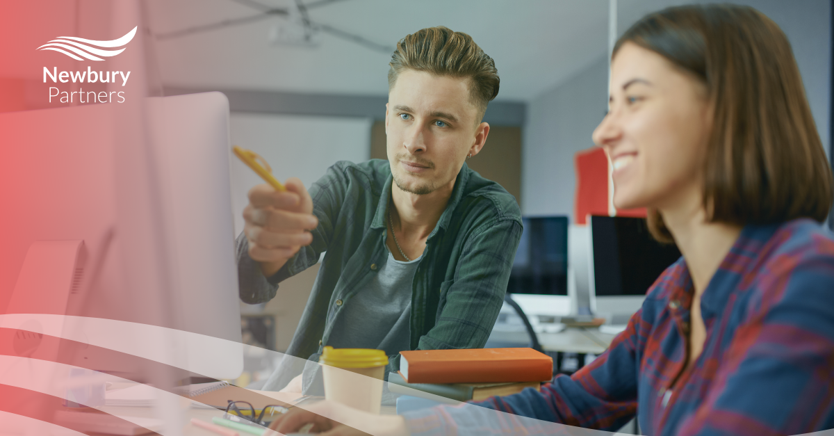 A man and a woman sitting at a computer.