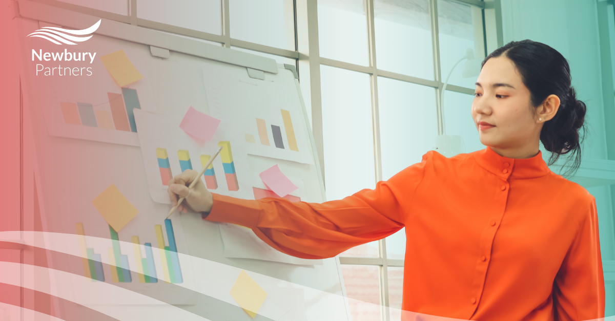 A woman writing on a board with sticky notes on it.